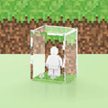 Pixel grass graphic printed onto the back of a clear acrylic display case for a single LEGO minifigure